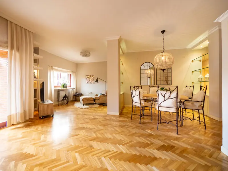Salón comedor con suelo de roble en espiga, lámpara de mimbre y mesa de comedor